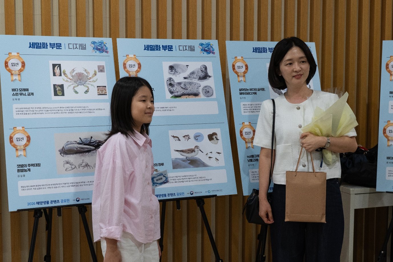 동자아트홀 로비에 마련된 수상작 전시를 배경으로 선 수상자와 가족